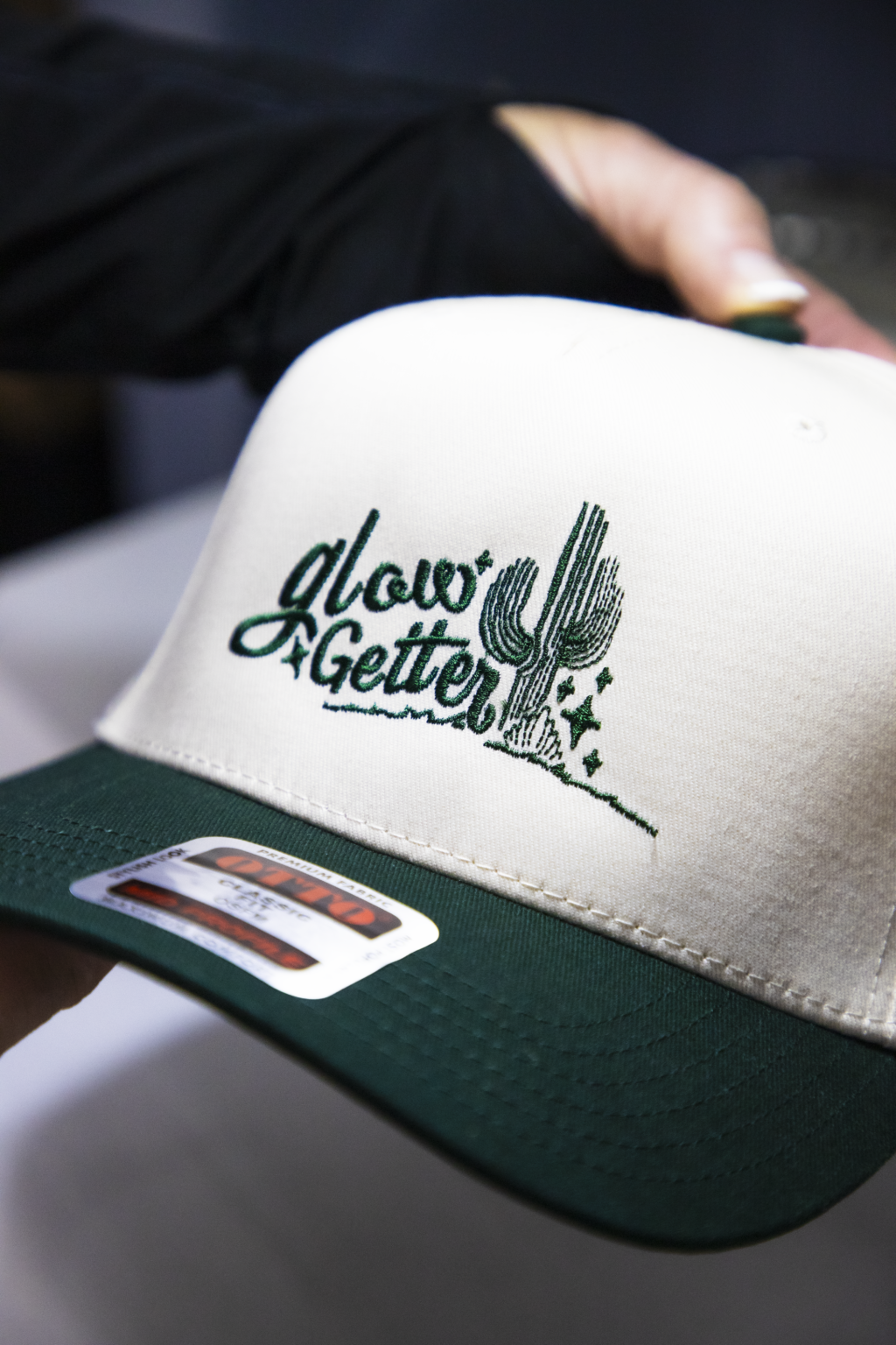 Custom embroidered design for Glow Getter on white and green trucker hat