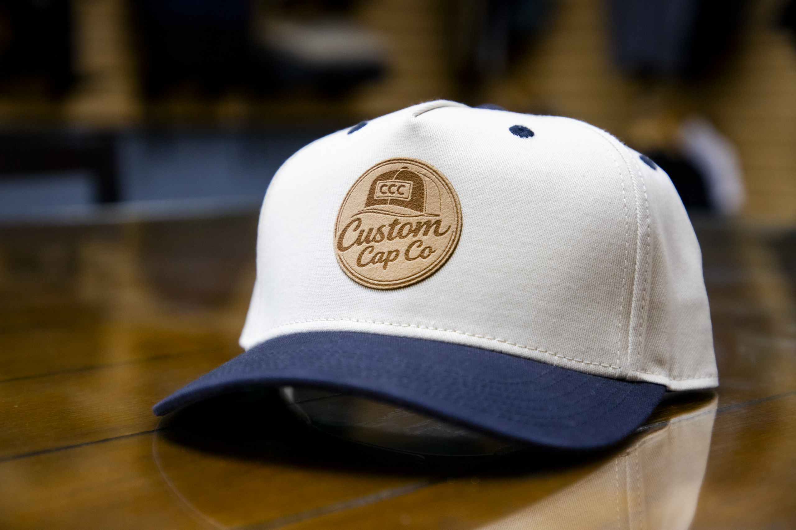 Custom leather patch hat with Custom Cap Co logo on white and navy cap