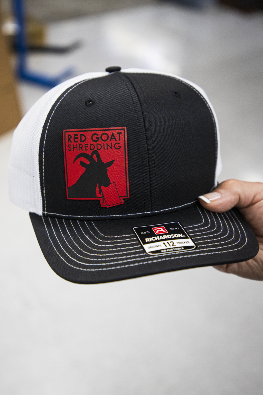 Custom printed logo for Red Goat Shredding on black and white trucker cap